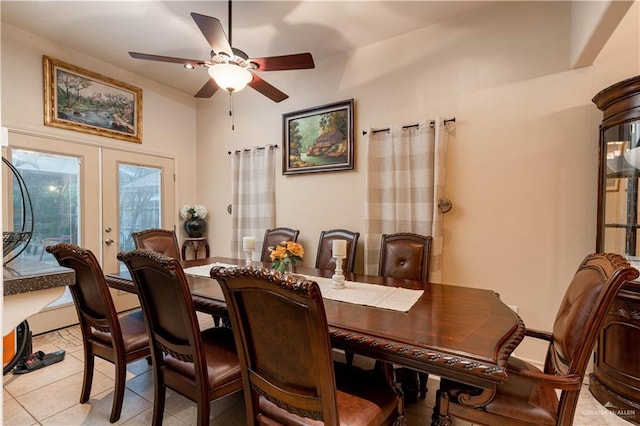 tiled dining room featuring ceiling fan and french doors