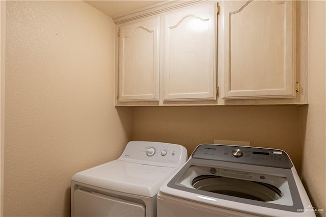 laundry room with washer and dryer and cabinets