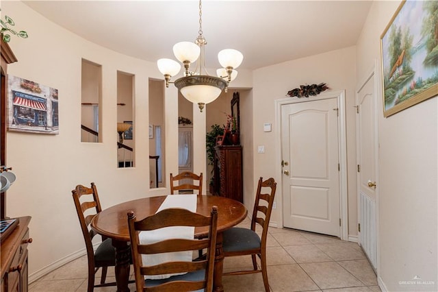 dining area with light tile patterned floors and an inviting chandelier