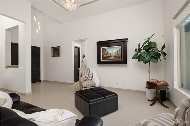 tiled living area featuring a notable chandelier and a towering ceiling