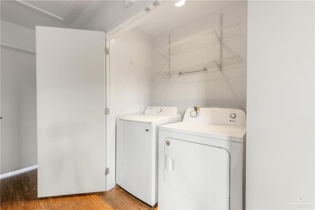 clothes washing area featuring washing machine and dryer and light wood-type flooring