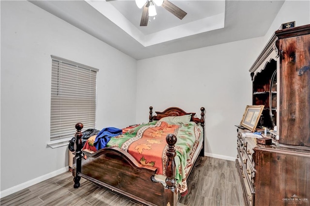 404 S 21st St, Mcallen, TX 78501 - bedroom featuring baseboards, wood tiled floors, a tray ceiling, and a ceiling fan