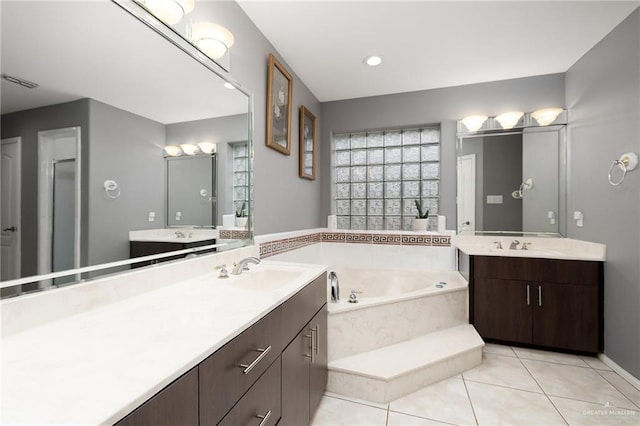 bathroom with a bath, vanity, and tile patterned floors