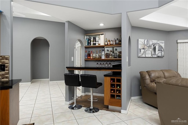 bar featuring light tile patterned floors