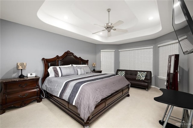 bedroom with a tray ceiling, ceiling fan, and light colored carpet