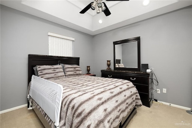 bedroom featuring light carpet, a raised ceiling, and ceiling fan