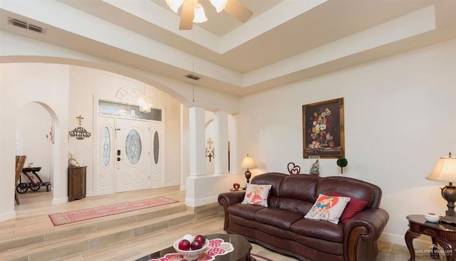 living room with hardwood / wood-style floors, ceiling fan, and a tray ceiling