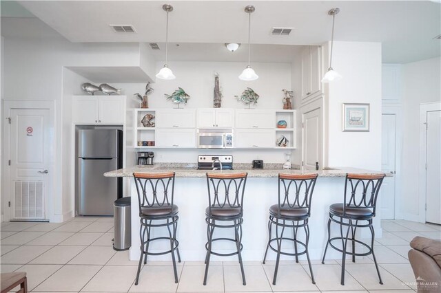 112 E Acapulco St E Unit 3, South Padre Island, TX 78597 - kitchen with stainless steel appliances, open shelves, and a breakfast bar area