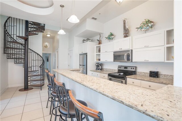 112 E Acapulco St E Unit 3, South Padre Island, TX 78597 - kitchen featuring stainless steel appliances, open shelves, white cabinetry, a kitchen breakfast bar, and light tile patterned floors