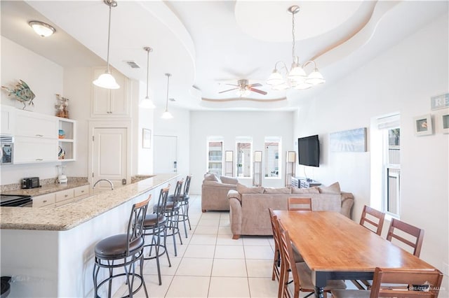 112 E Acapulco St E Unit 3, South Padre Island, TX 78597 - dining area featuring light tile patterned floors, a tray ceiling, ceiling fan, and a chandelier