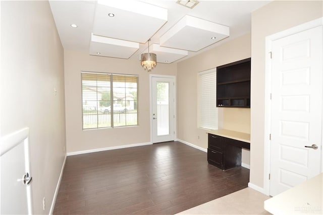 doorway to outside with built in desk, wood-type flooring, and an inviting chandelier