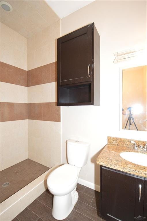 bathroom with walk in shower, tile patterned flooring, vanity, and toilet