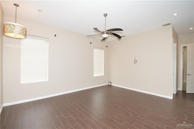 empty room with ceiling fan and dark hardwood / wood-style flooring