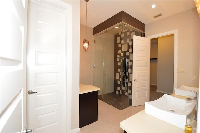 bathroom featuring tiled shower and vanity