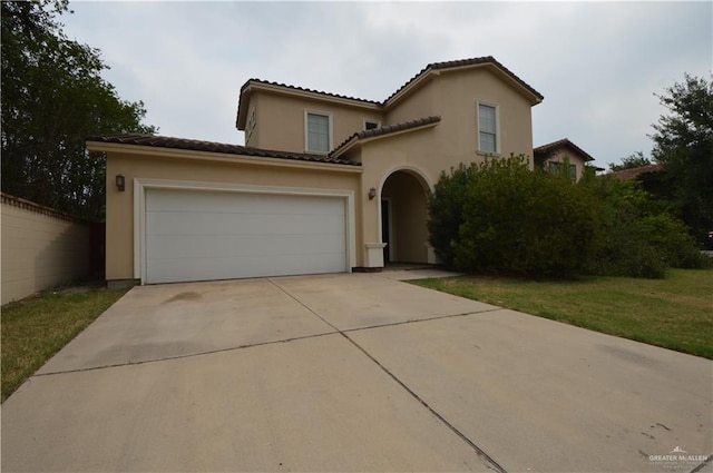 mediterranean / spanish-style house with a garage and a front lawn