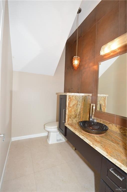 bathroom featuring toilet, tile patterned floors, and lofted ceiling