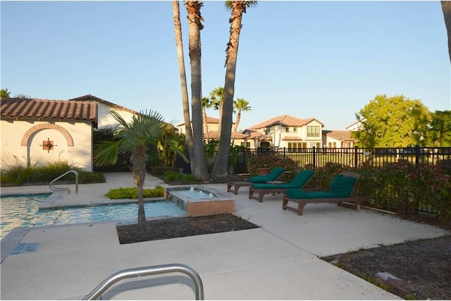 view of pool with a patio area and an in ground hot tub