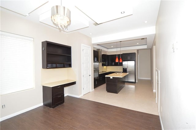 kitchen with dark wood-type flooring, an inviting chandelier, stainless steel refrigerator with ice dispenser, pendant lighting, and a kitchen island