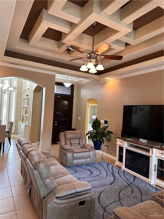 living room with coffered ceiling, ceiling fan, ornamental molding, and light tile patterned flooring