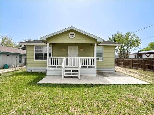 rear view of house with a yard, a patio, covered porch, and fence