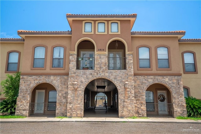 2815 Mimosa St Unit 6, Mission, TX 78574 - view of front of house featuring stucco siding, a balcony, and stone siding