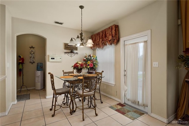 dining area featuring a chandelier and light tile patterned flooring