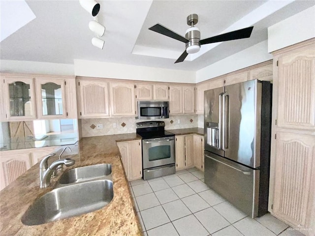 kitchen with ceiling fan, appliances with stainless steel finishes, a sink, and tasteful backsplash