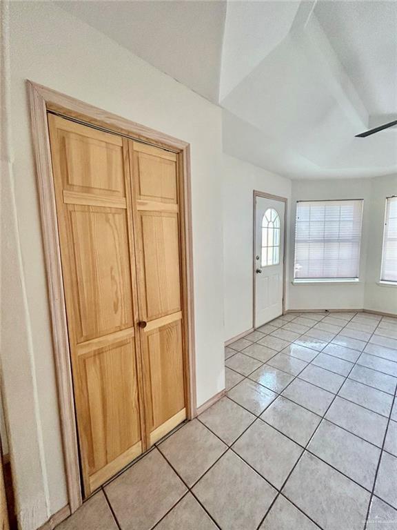 foyer featuring ceiling fan, baseboards, and light tile patterned floors