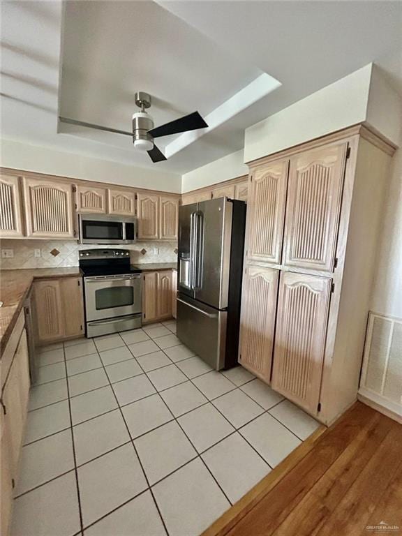 kitchen with light tile patterned floors, visible vents, light brown cabinetry, appliances with stainless steel finishes, and ceiling fan