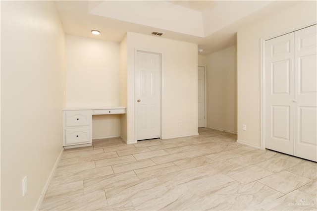 unfurnished bedroom featuring built in desk