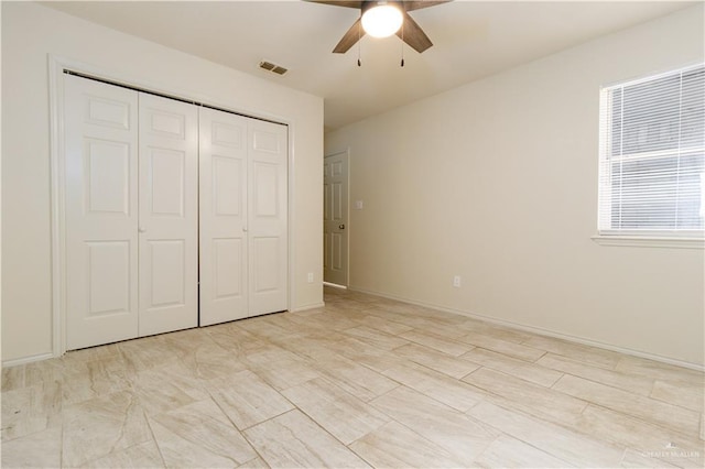 unfurnished bedroom featuring ceiling fan and a closet