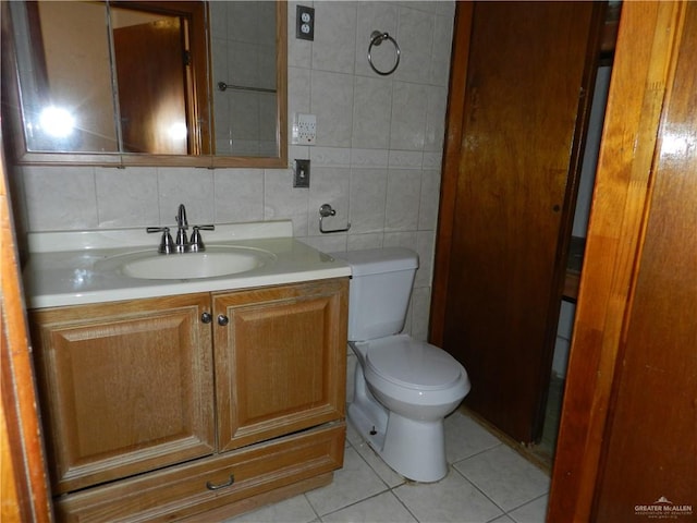 bathroom with decorative backsplash, vanity, tile walls, tile patterned flooring, and toilet