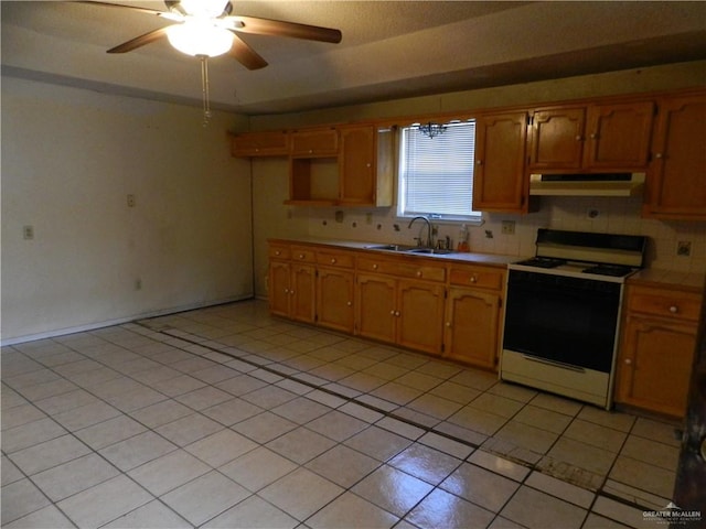 kitchen featuring backsplash, sink, light tile patterned floors, and white range