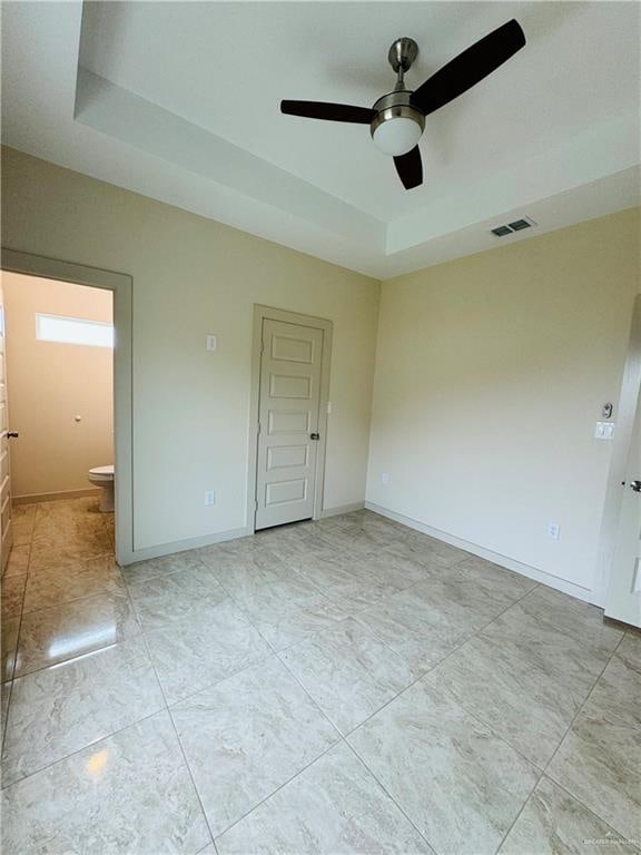 unfurnished room featuring a tray ceiling and ceiling fan