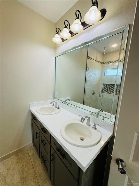 bathroom with tile patterned floors, vanity, and a shower with door