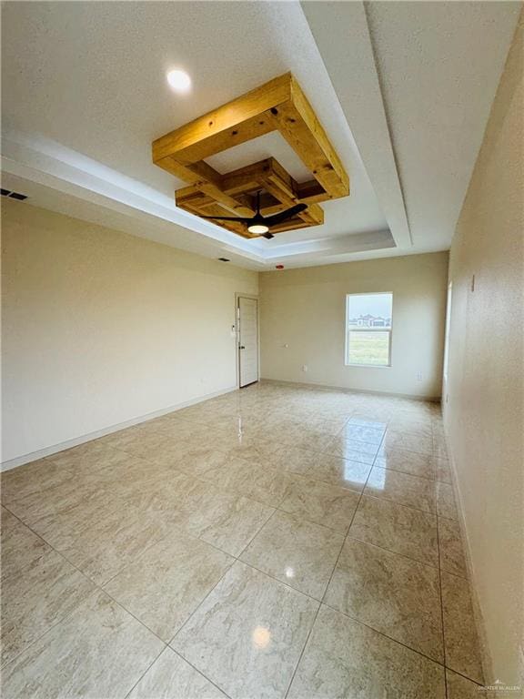 spare room with beam ceiling, a tray ceiling, ceiling fan, and coffered ceiling