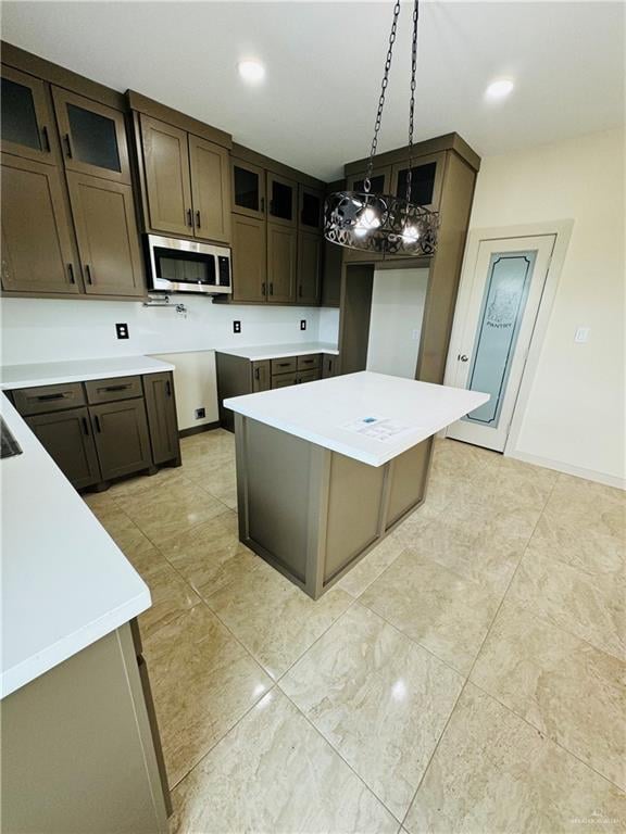 kitchen with pendant lighting, dark brown cabinets, and a kitchen island