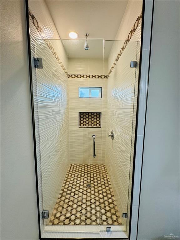 bathroom with a shower with door