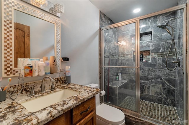 bathroom featuring vanity, an enclosed shower, and toilet