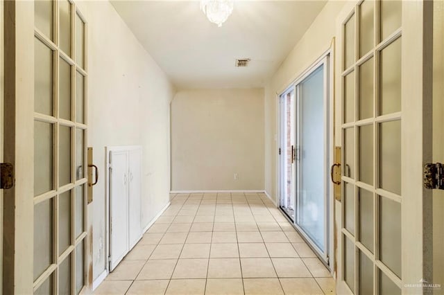 corridor featuring light tile patterned floors and french doors