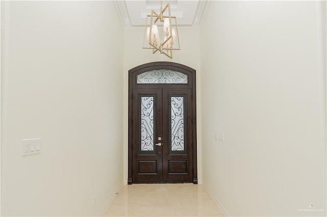 entrance foyer featuring french doors, ornamental molding, and a notable chandelier