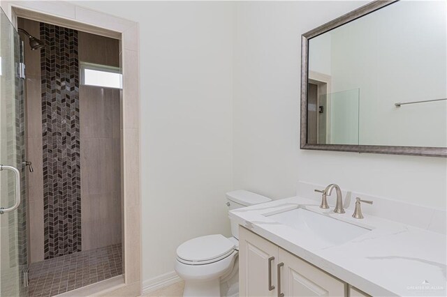 bathroom featuring vanity, an enclosed shower, and toilet