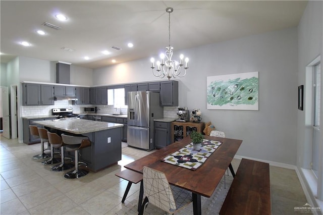 kitchen with appliances with stainless steel finishes, sink, pendant lighting, a center island, and gray cabinets