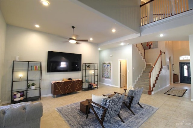 living room with a towering ceiling and ceiling fan