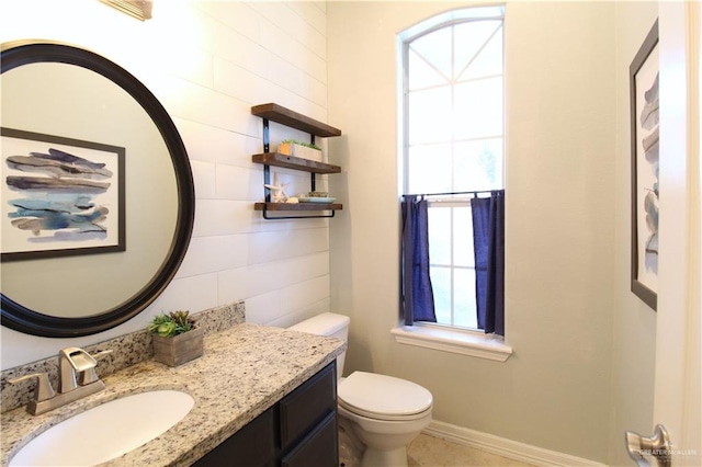 bathroom with vanity, toilet, and a wealth of natural light