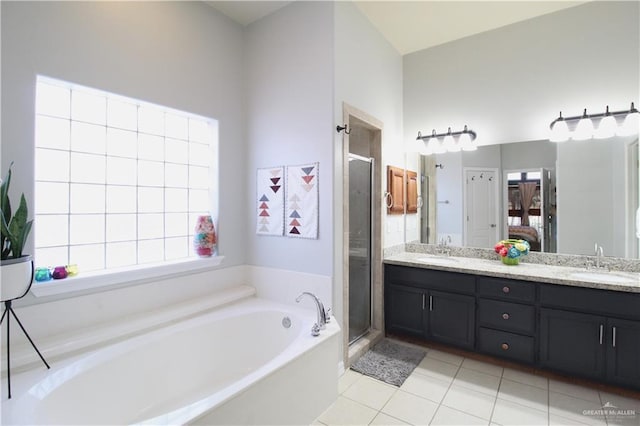 bathroom featuring tile patterned floors, vanity, and shower with separate bathtub