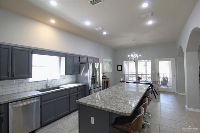 kitchen featuring plenty of natural light, a center island, sink, and stainless steel appliances