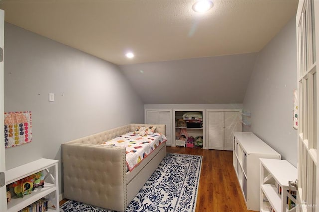 bedroom with dark hardwood / wood-style floors and vaulted ceiling