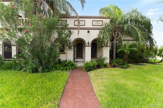 mediterranean / spanish home featuring a front lawn