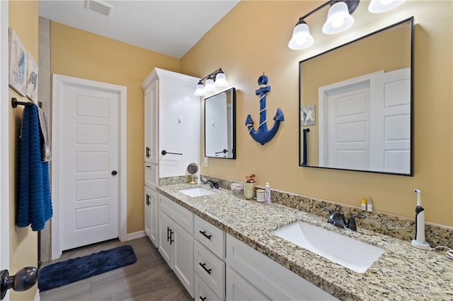9713 Alexis Ave, Harlingen, TX 78552 - full bath with double vanity, wood finished floors, and baseboards